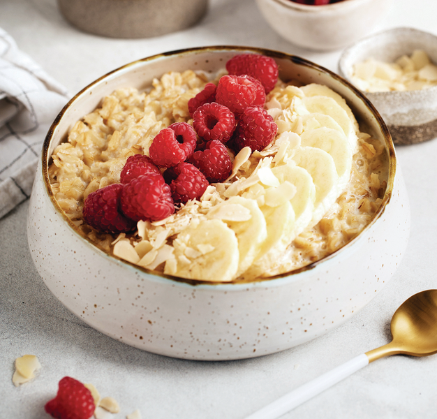 Oatmeal in milk with banana and raspberries
