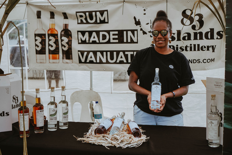 Ni-vanuatu woman holding a bottle, 83 Island Distillery, Vanuatu Market Day, Efate island, Shefa Province, Vanuatu. Photo: Vanuatu Tourism Office