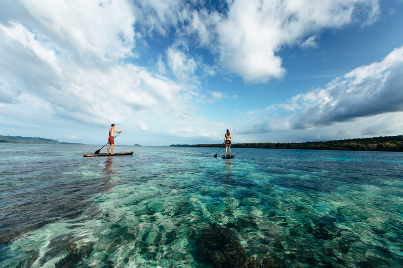 Two tourist paddles on surf boards off shore from Ratua Island Resort, Sanma province, Vanuatu. Photo: Vanuatu Tourism Office/We Are Explorers